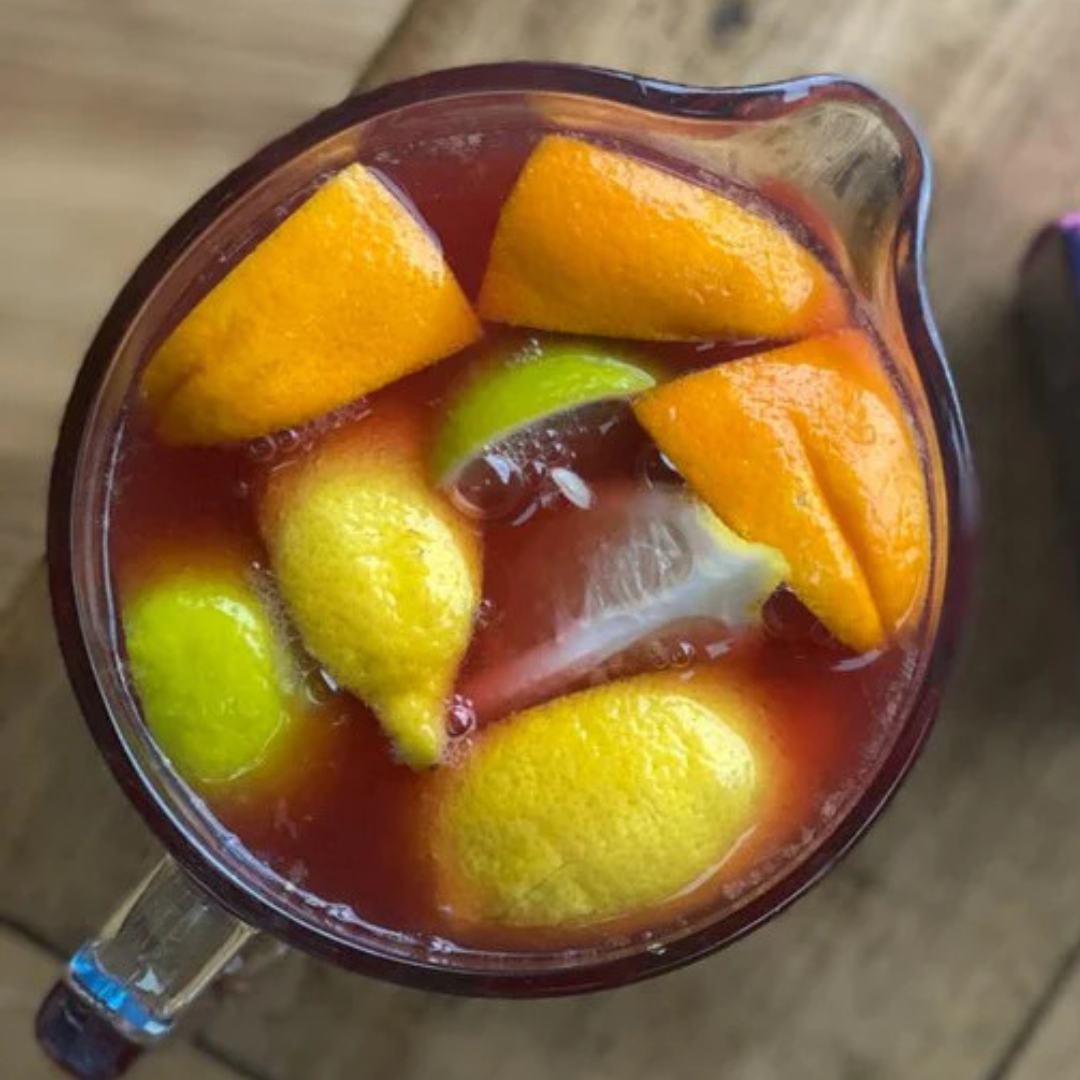 Jug full of fruit and tea sangria, on table next to pack of Baby It's Cold Outside tea