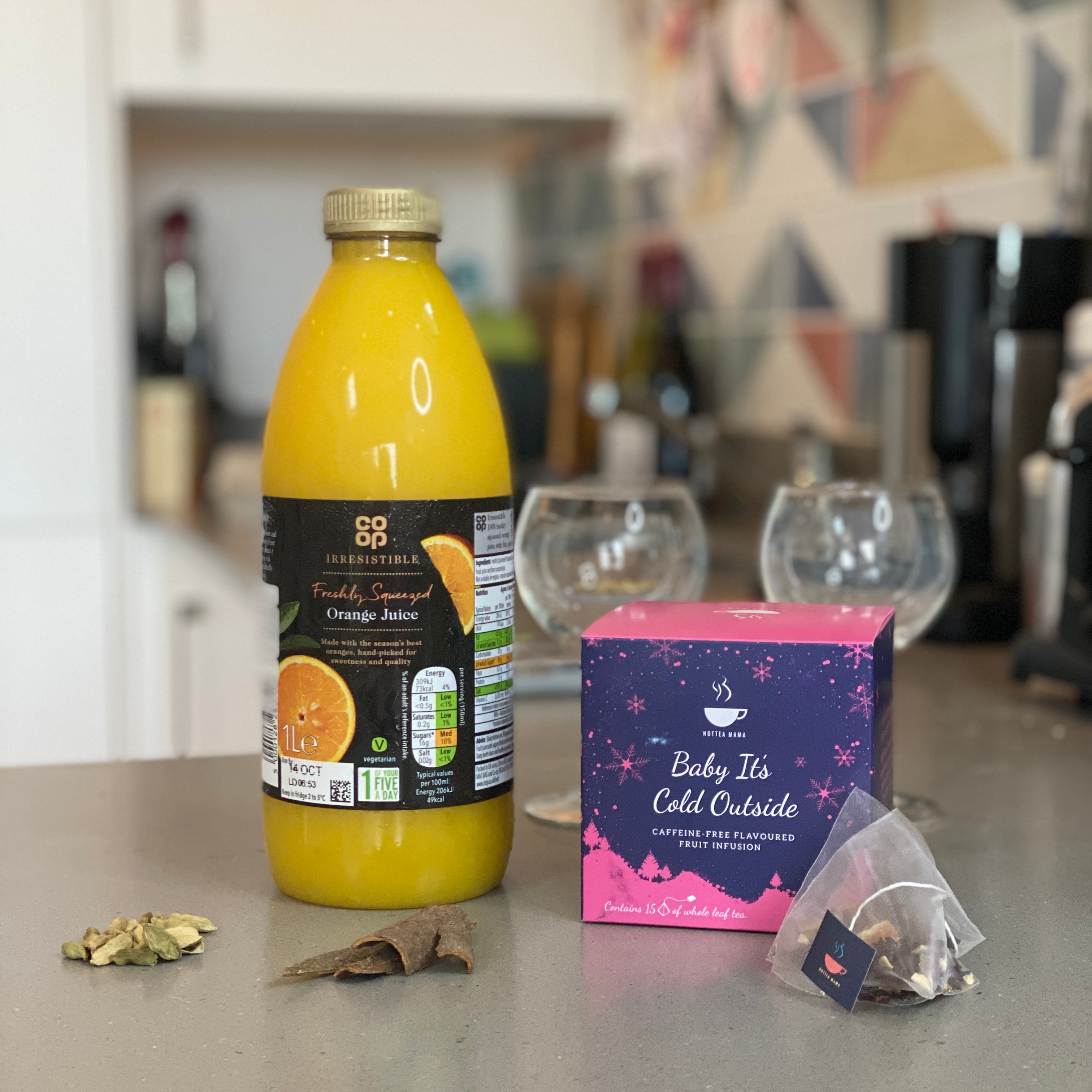 Orange juice, Baby It's Cold Outside Tea and glasses on kitchen surface