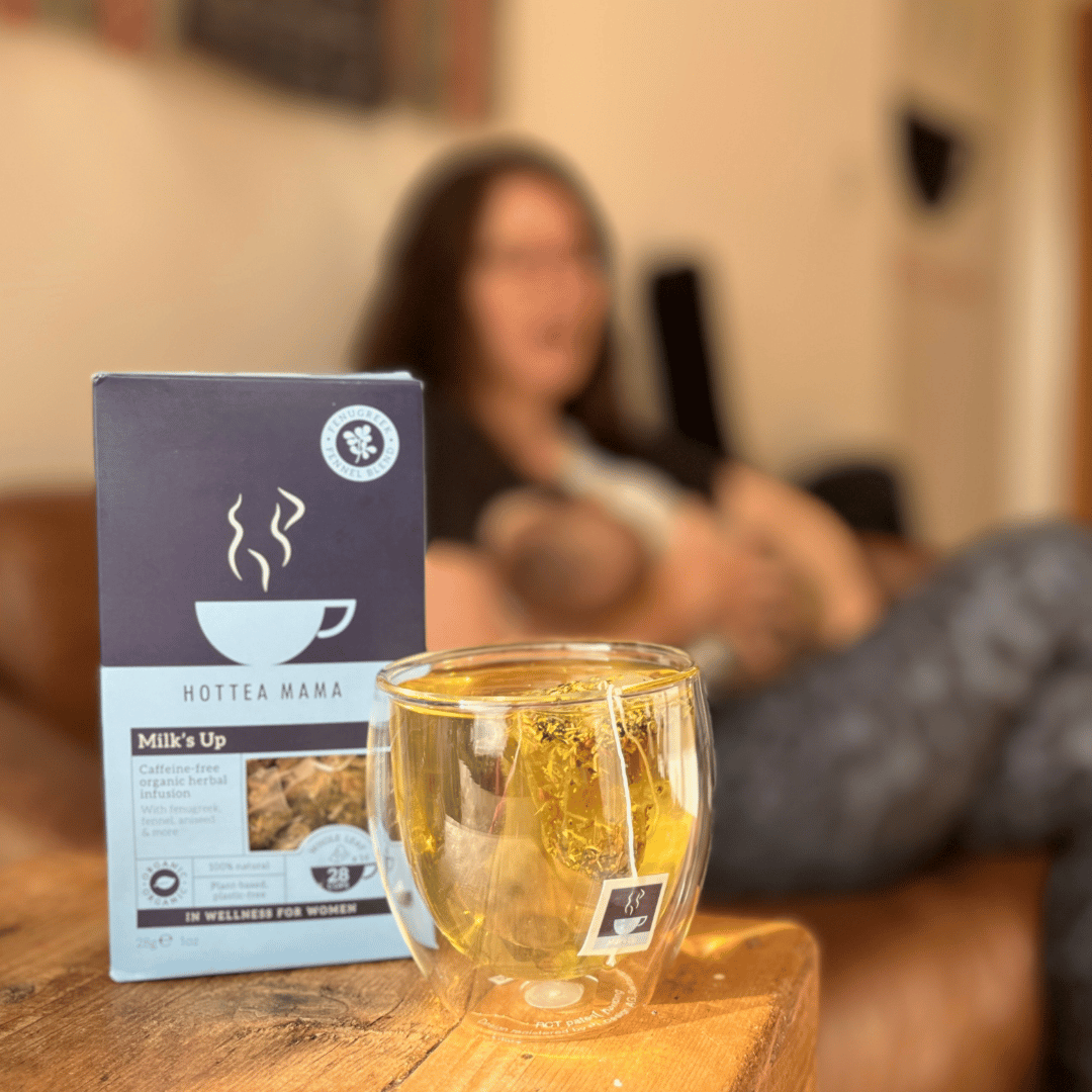Image of mum breastfeeding babay with a pack of HotTea Mama Milk's Up breastfeeding support tea in foreground