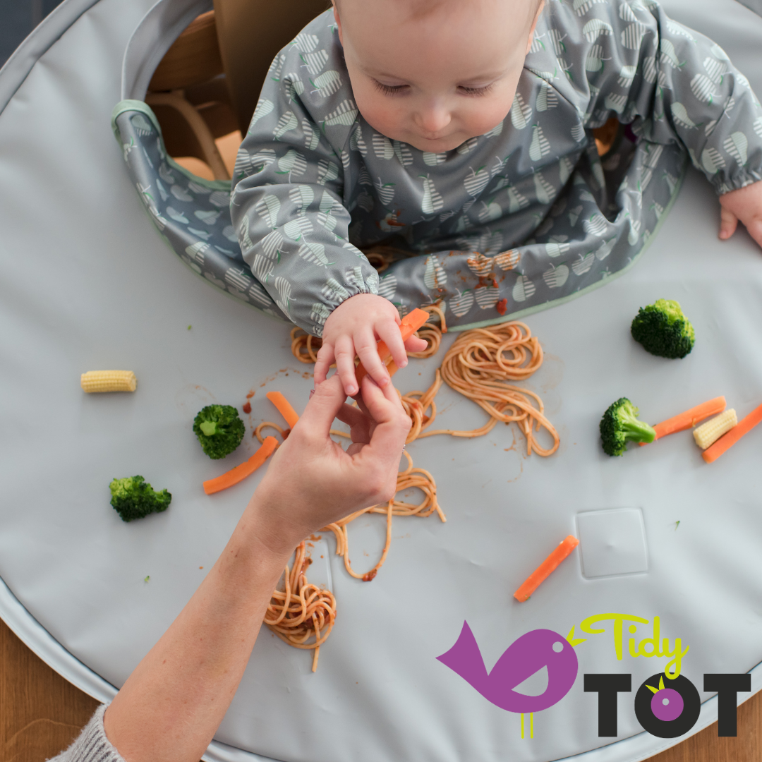 Image of a baby being weened with a Tidy Tot bib and tray mat