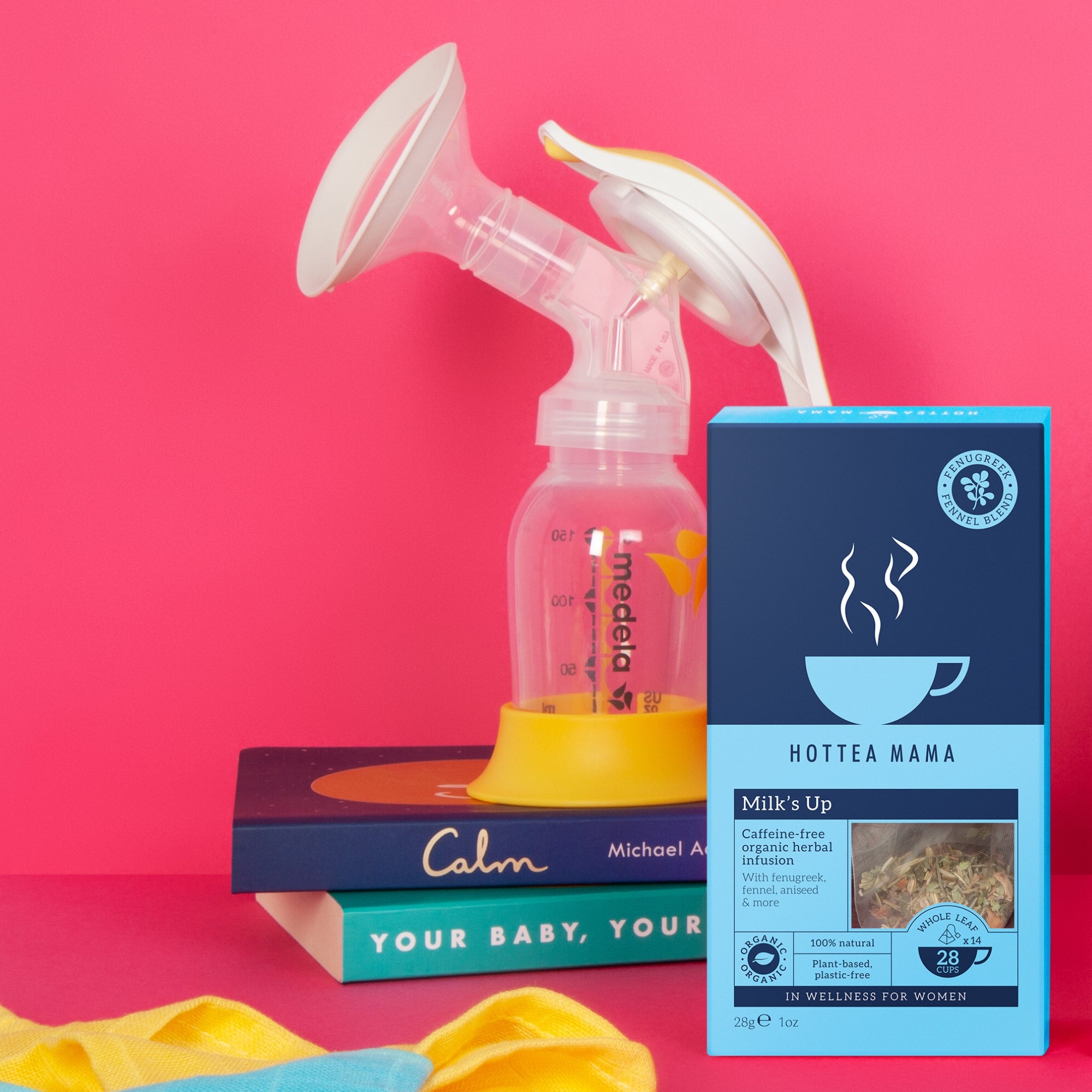 HotTea Mama Milks Up Breastfeeding Tea with breast pump and lactation support books with muslins on pink background