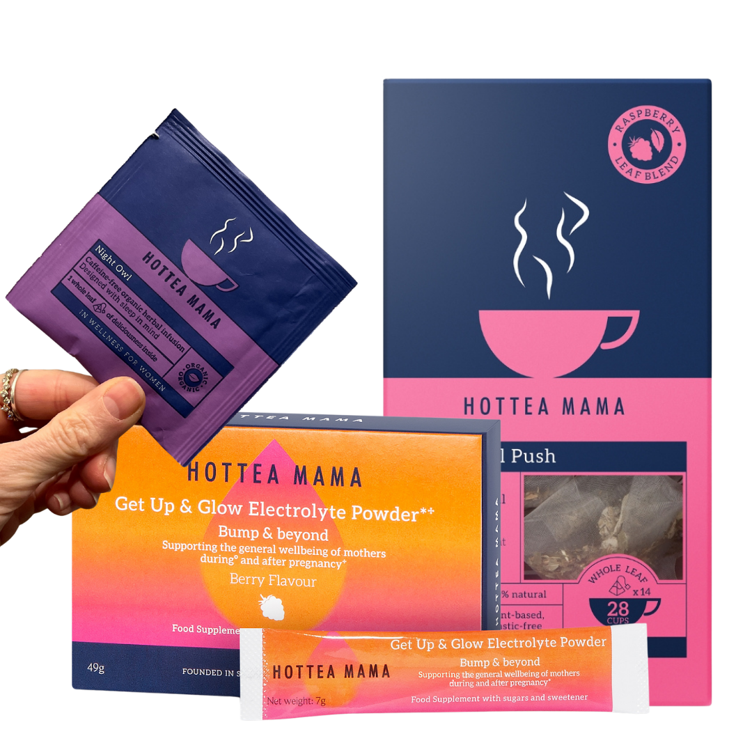 A hand holds a purple Hottea Mama Night Owl tea bag packet in front of a larger orange and pink Hottea Mama electrolyte product box, with additional matching packets and a tea bag visible on a clean white background.