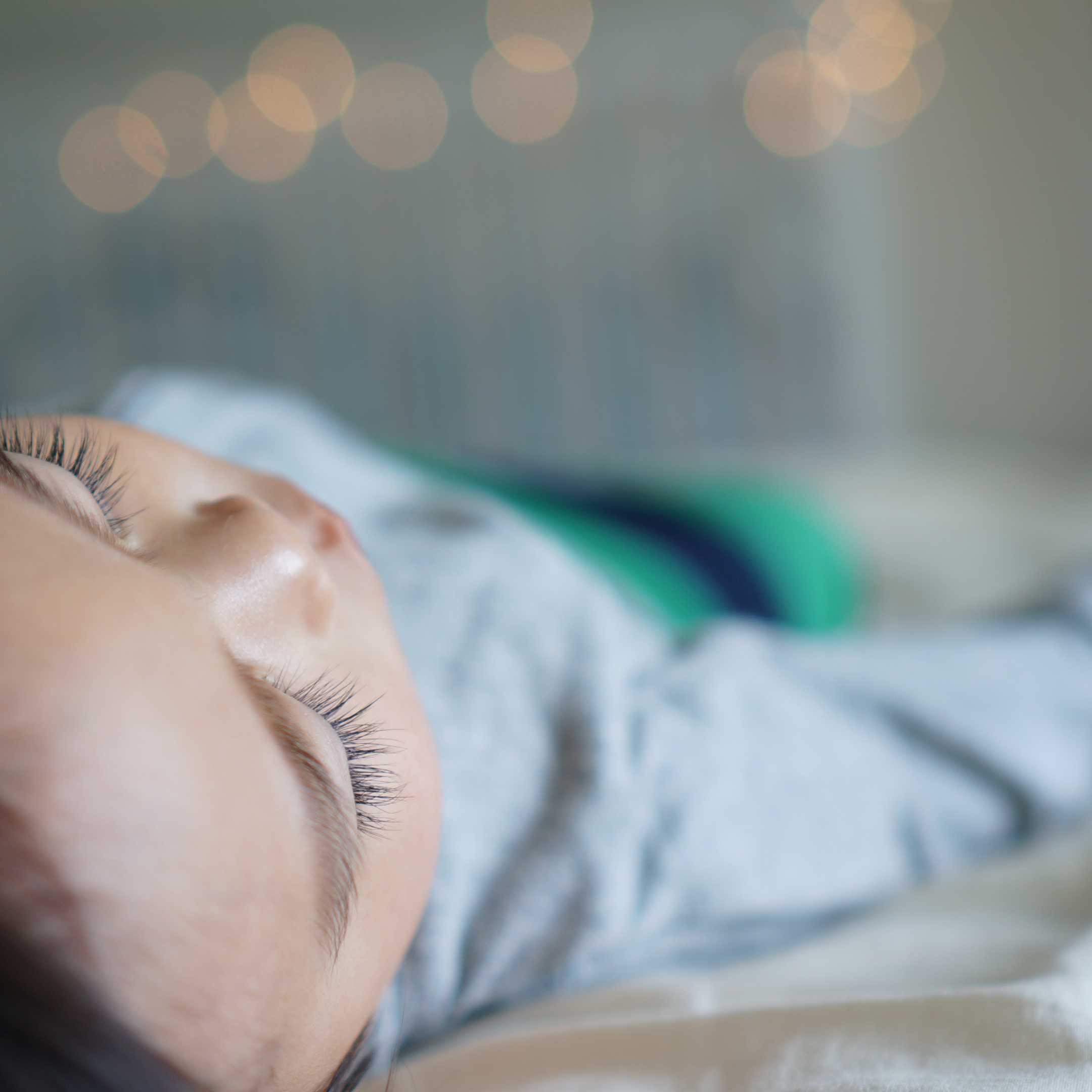 Baby sleeping with twinkling lights in the background