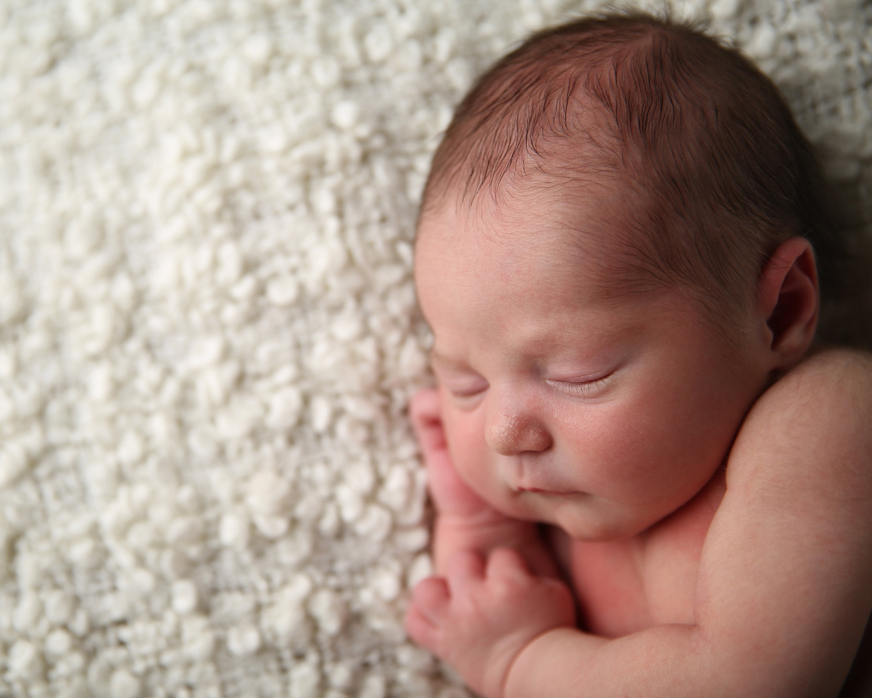 Sleeping baby on sheep skin rug