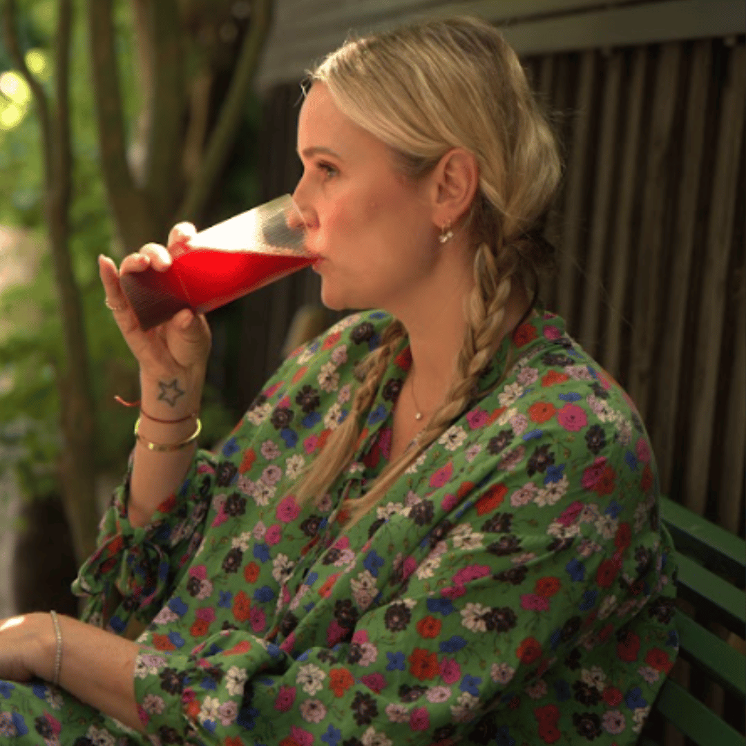Image of a woman sat drinking Hiro electrolyte drink