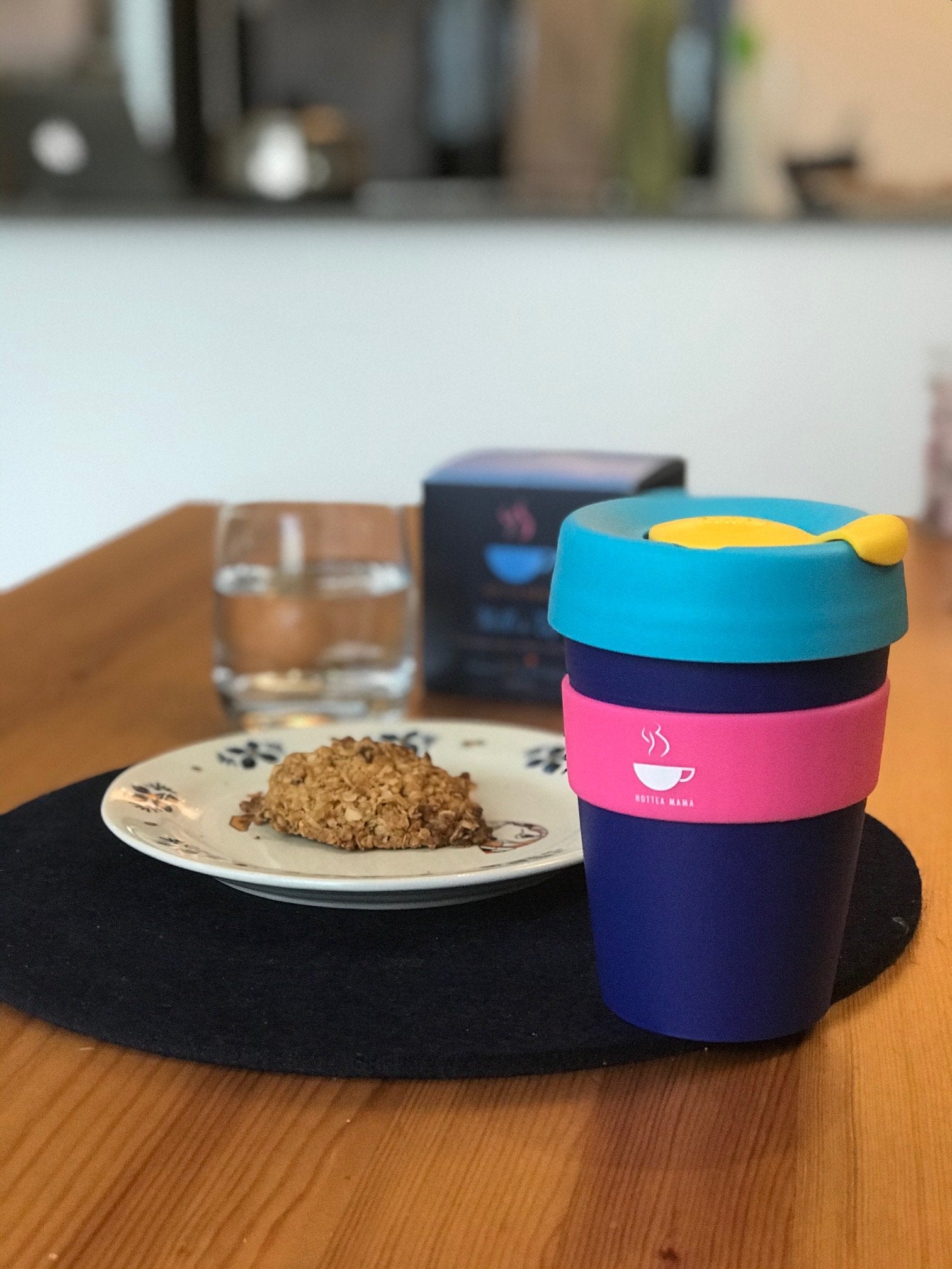 Lactation cookie on plate, with mug and Milk's Up breastfeeding tea next to it on table