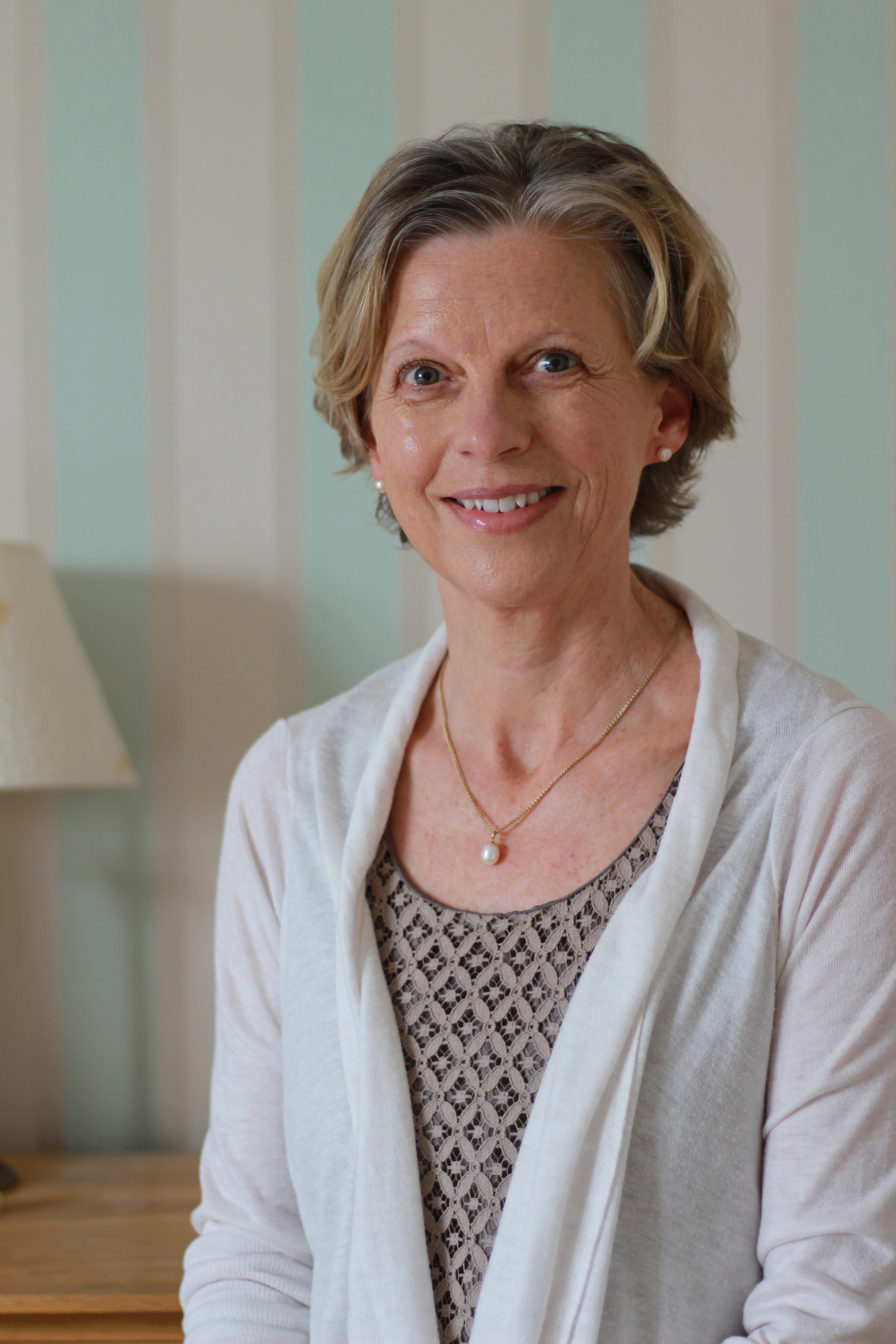 Menopausal woman sat, smiling at camera