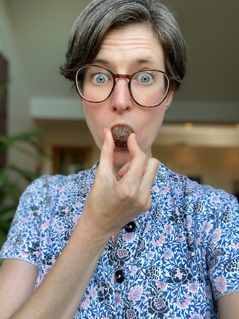 Woman holding a chocolate ball up to eat