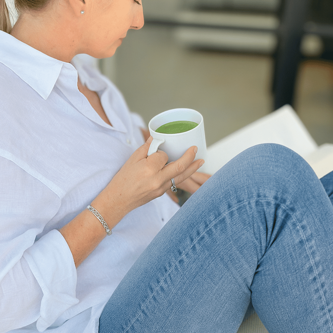 Image of a woman reading a book drinking Mind Over Matcha