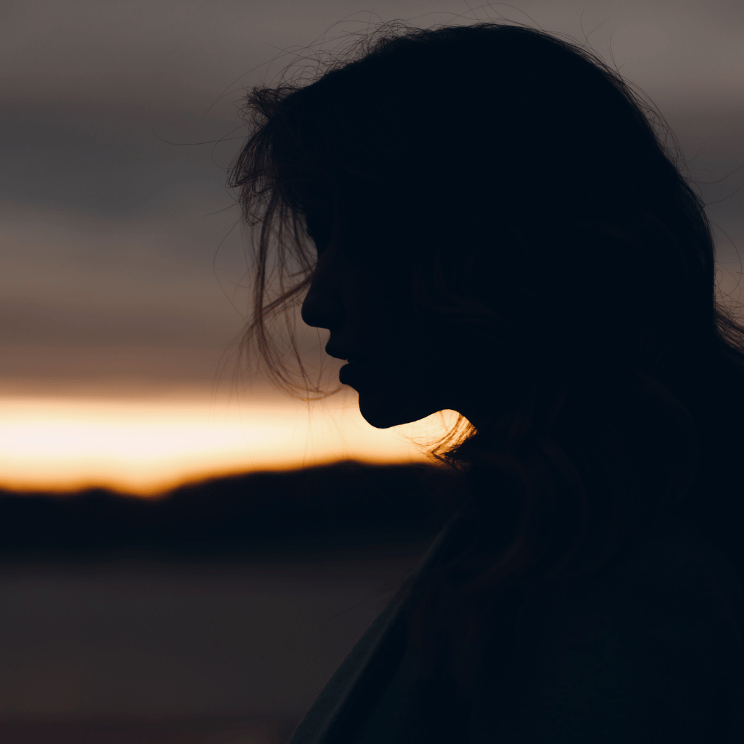Silhouette of a woman looking out in to the distance