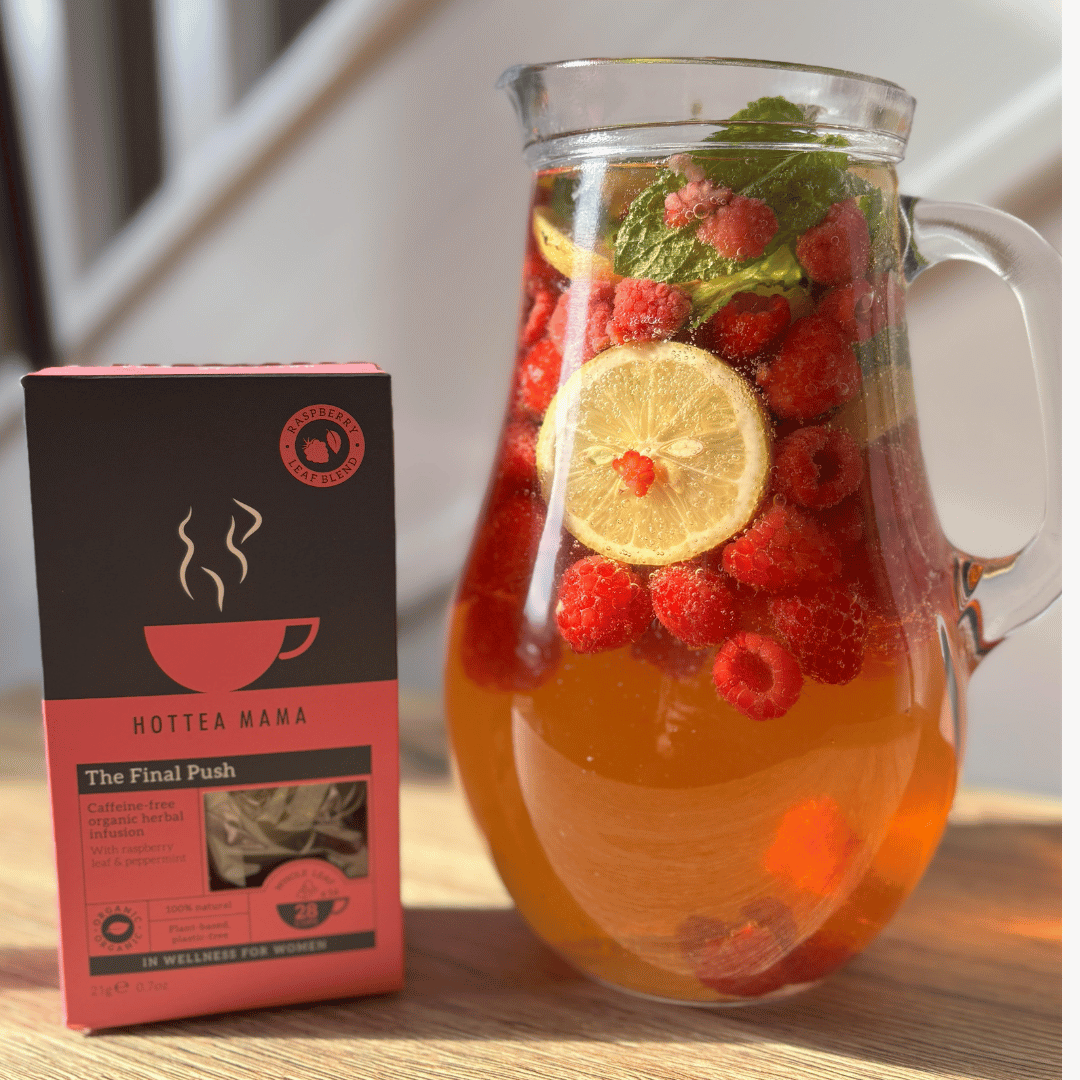Image of HotTea Mama's The Final Push Raspberry Leaf tea next to a jug of iced tea garnished with fruit