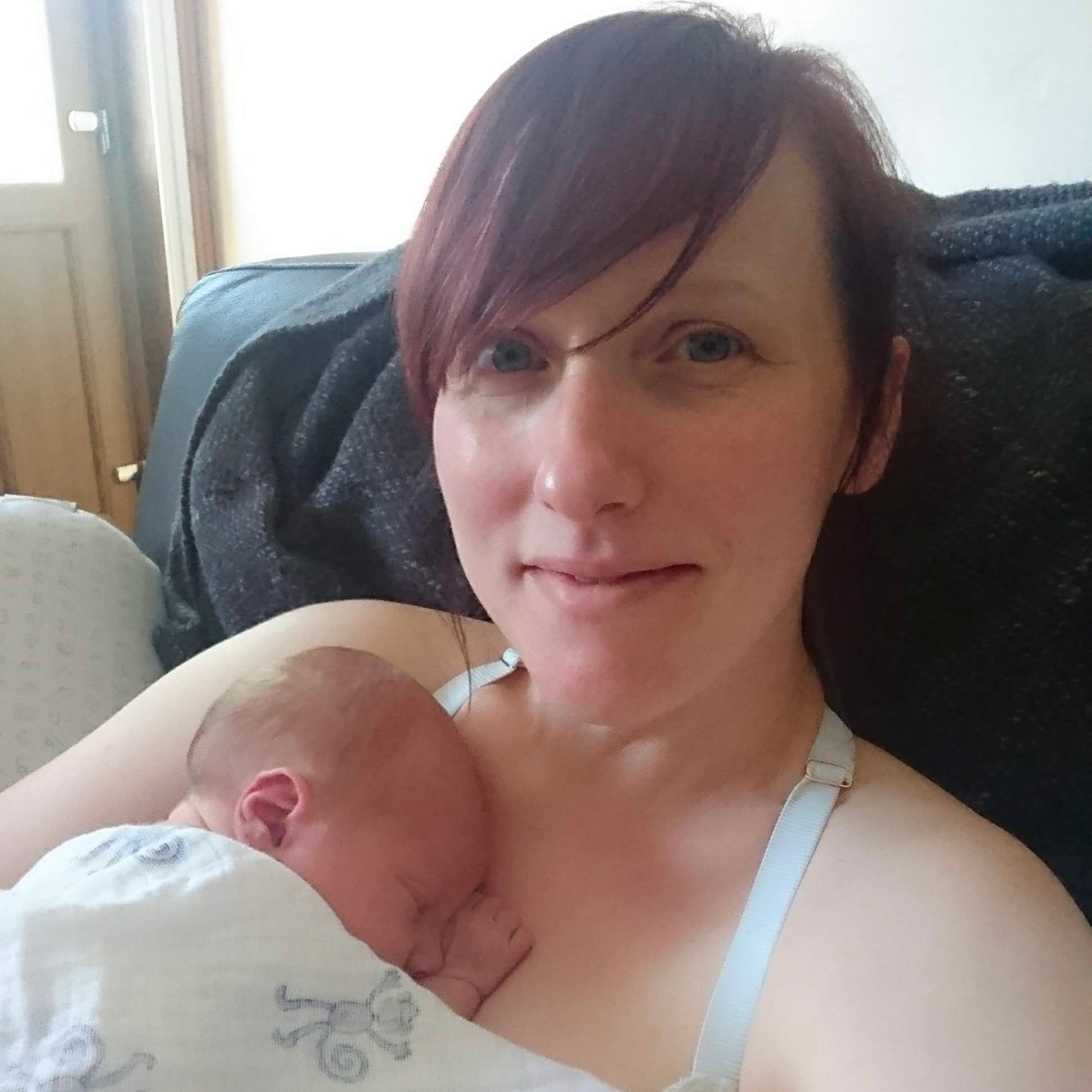 Mum with newborn baby on her chest looking tired