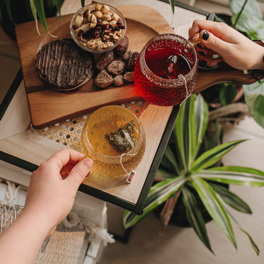 Lifestyle image of HotTea Mama teas brewed in glass mugs with a tray of healthy and nutritious snacks