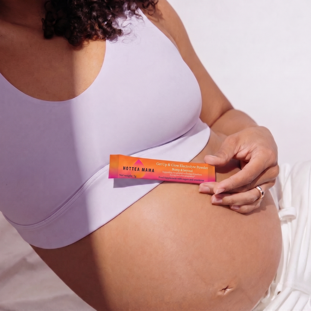 Pregnant woman holding a Get Up & Glow Electrolyte powder against her baby bump against a white background